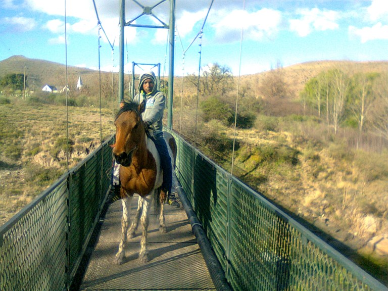 Nieu Bethesda-boy on horse on footbridge